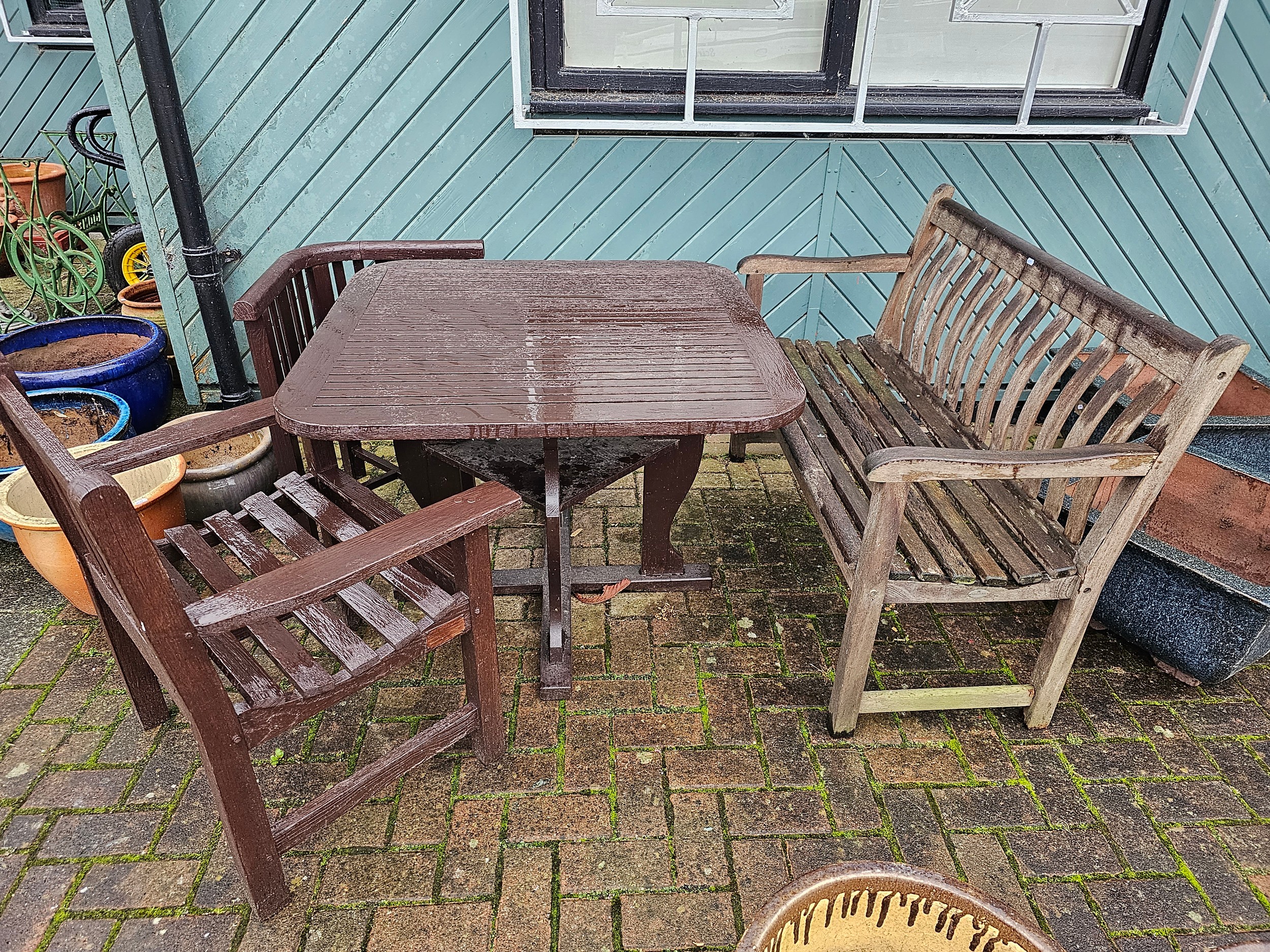 A square hardwood garden table, two armchairs and a bench