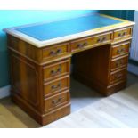 A modern yew wood twin pedestal desk, the top with inset leather skiver above two banks of three