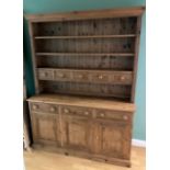 A modern pine kitchen dresser, the upper section having plate rack with spice drawers above three