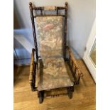 A late 19th century American stained beech rocking chair, the turned frame with spindle arm supports