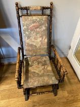 A late 19th century American stained beech rocking chair, the turned frame with spindle arm supports