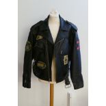 A medium sized ACME Clothing black leather motorcycle jacket, with various cloth badges applied.