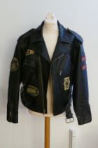 A medium sized ACME Clothing black leather motorcycle jacket, with various cloth badges applied.