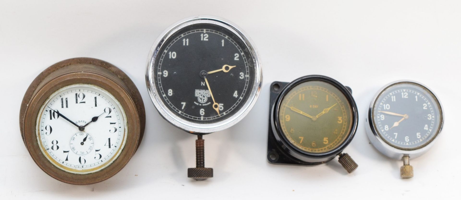 A group of four 20th century dashboard clocks comprising Smiths of London, the black dial with white