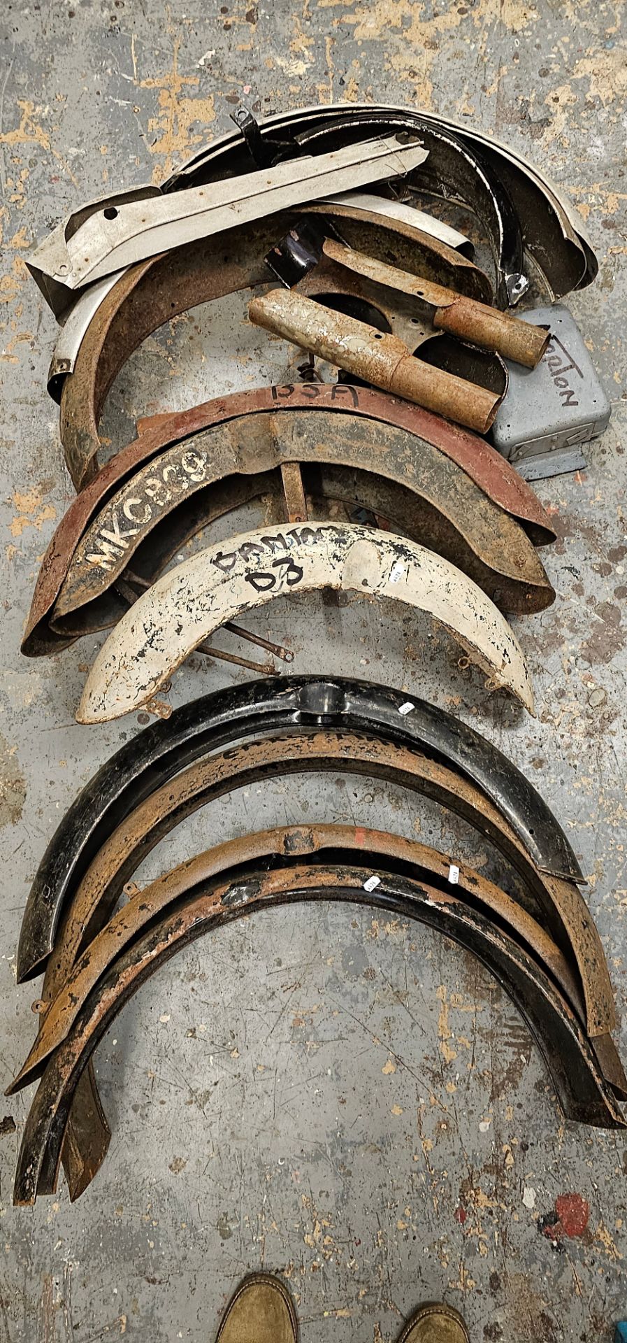 A collection of vintage British motorcycle mudguards.