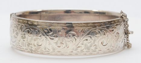 A silver cuff bangle with foliate engraving, 62mm, Birmingham 1959, 46gm.