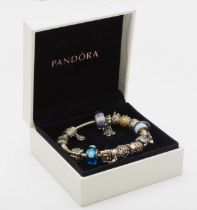 Pandora, a silver charm bracelet to include glass charms, 67gm.