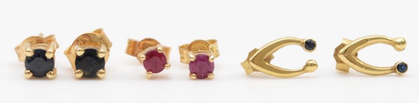 A pair of gold sapphire ear studs, a pair of ruby ear studs and a pair of sapphire wish bone ear