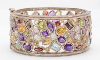 A unmarked silver gem set bangle to include amethyst, garnet and moonstone, 62mm, 117gm.