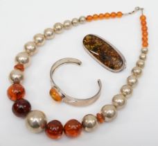 A Baltic amber beaded necklace, 7 - 20mm beads, a silver amber bangle, 62mm, and a silver amber