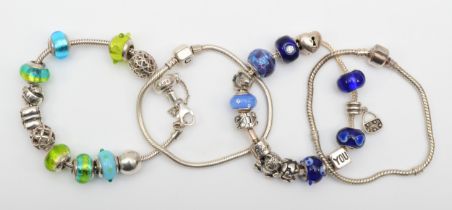 Four silver charm bracelets to include a Rhona Sutton example, 111gm.
