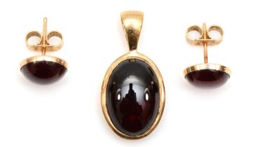 A 9ct gold garnet oval pendant, 22 x 10mm, and matching ear studs, 5gm.