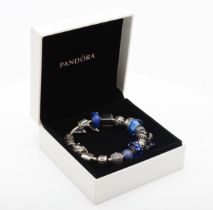 Pandora, a silver charm bracelet with charms to include glass examples, 72gm.