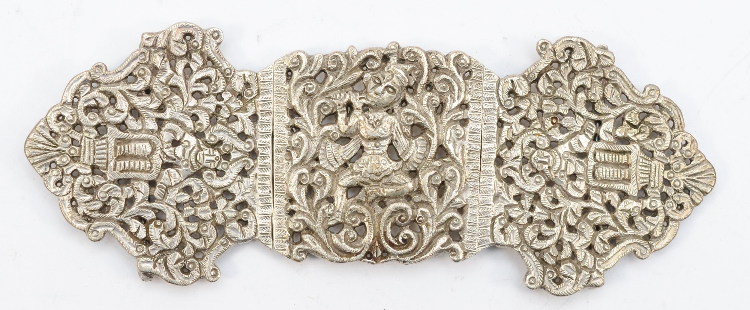 An Indian unmarked silver three section belt buckle with religious deity decoration, 14.5 x 5.5cm,