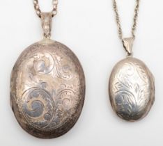 A silver oval locket with scroll engraving, 42 x 24mm, on chain, 15gm, with a larger plated example.