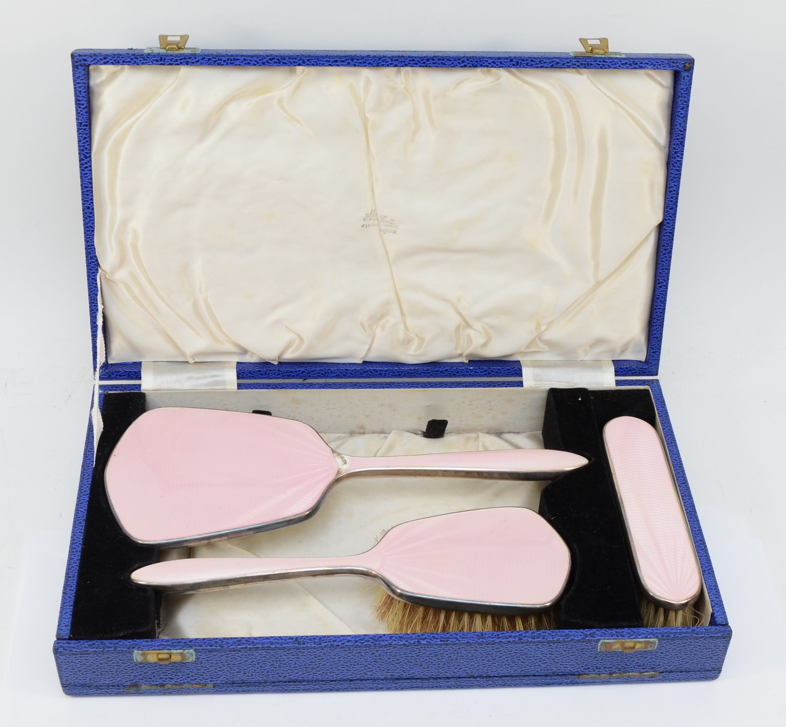 An Art Deco silver plated pink guilloche enameled dressing table set, cased.