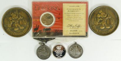 Two Disney medallions and a Liberty mint 1995 Lion king commemorative coin.