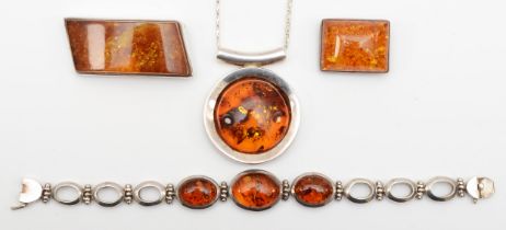 A silver Baltic amber pendent, 44 x 42mm, on chain, a silver amber bracelet and two brooches, 121gm.