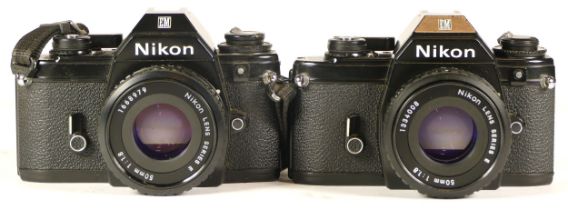 A Nikon EM camera complete with lens (woking but haze in the lens) together with a Nikon EM camera