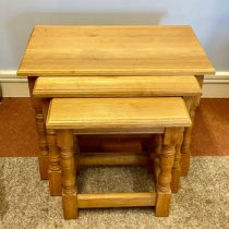 A modern solid oak nest of three tables.