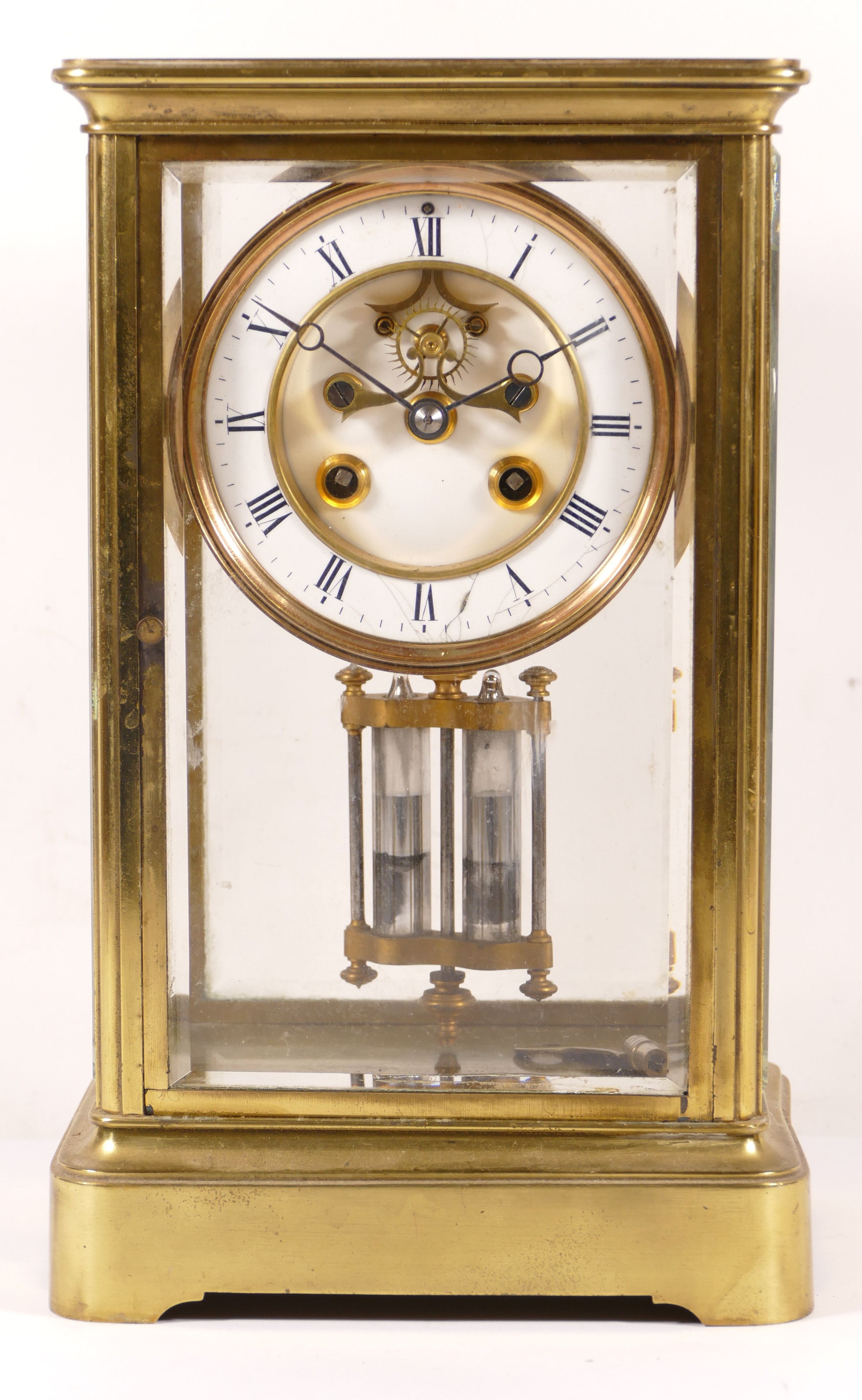 A late 19th/early 20th century brass corniche and four glass mantle clock, the white enamelled