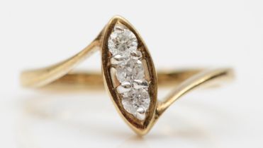 A 9ct gold three stone brilliant cut diamond ring, mounted in a navette setting, O, 2.6gm.