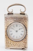 An Edwardian hammered silver miniature carriage clock, by Henry Matthews Birmingham 1921, with swing