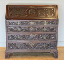A late 19th century carved mahogany fall front bureau, opening to reveal fitted interior with four