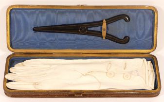 A late 19th century cased pair of gloves with a pair of glove stretchers, 27cm wide.