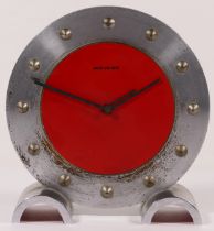 Movado, a mid 20th century brushed steel and red painted desk clock, with applied numerals raised on