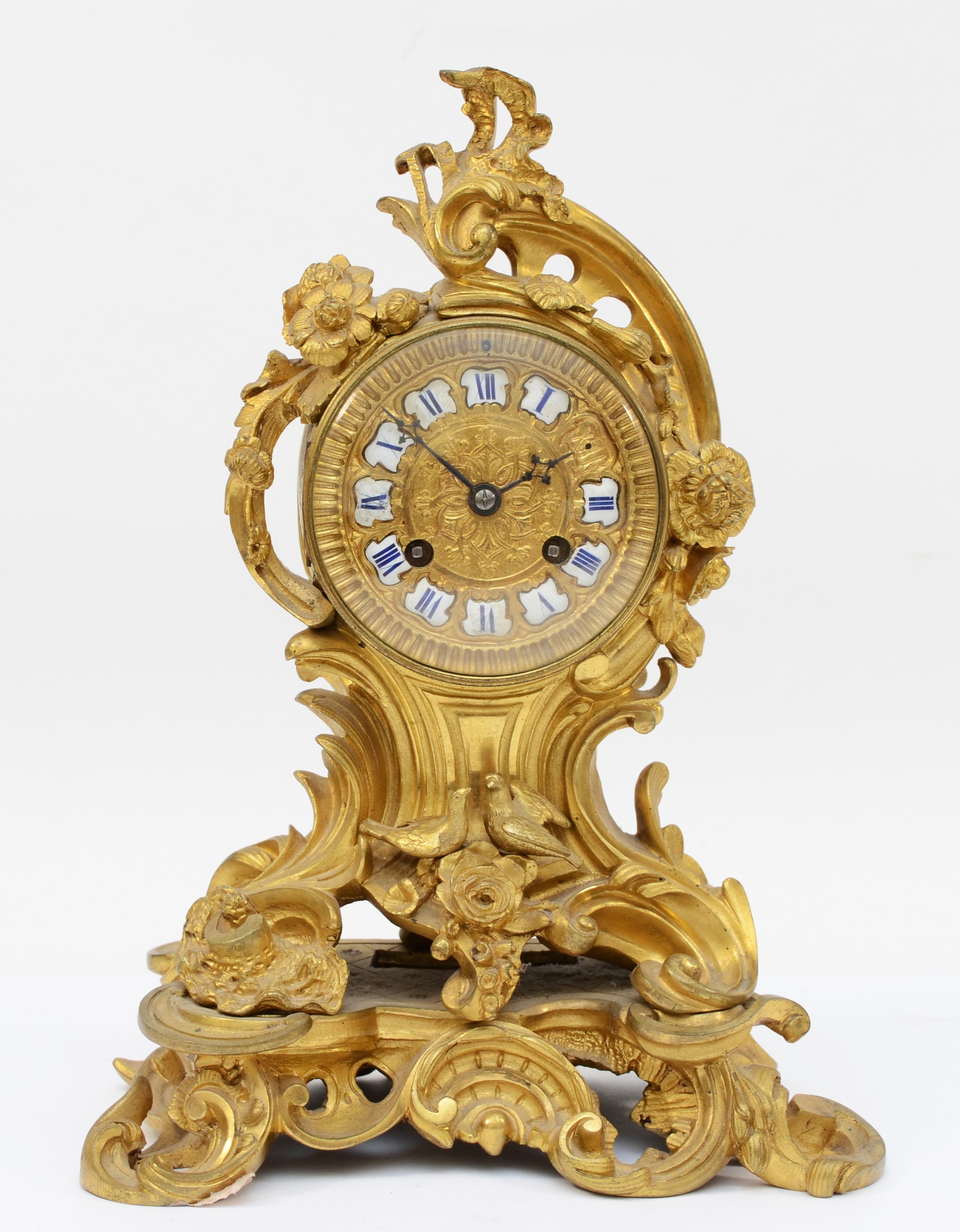 A late 19th century, probably French gilt brass mantle clock, the gilt dial with applied enamel