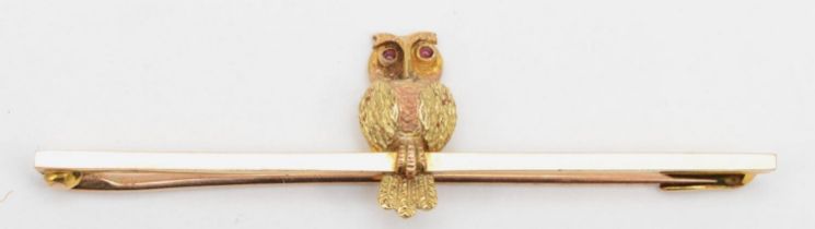 A Victorian 9ct twin coloured gold bar brooch with perched owl and ruby eyes, 5 x 1.5 cm, 2.1gm.