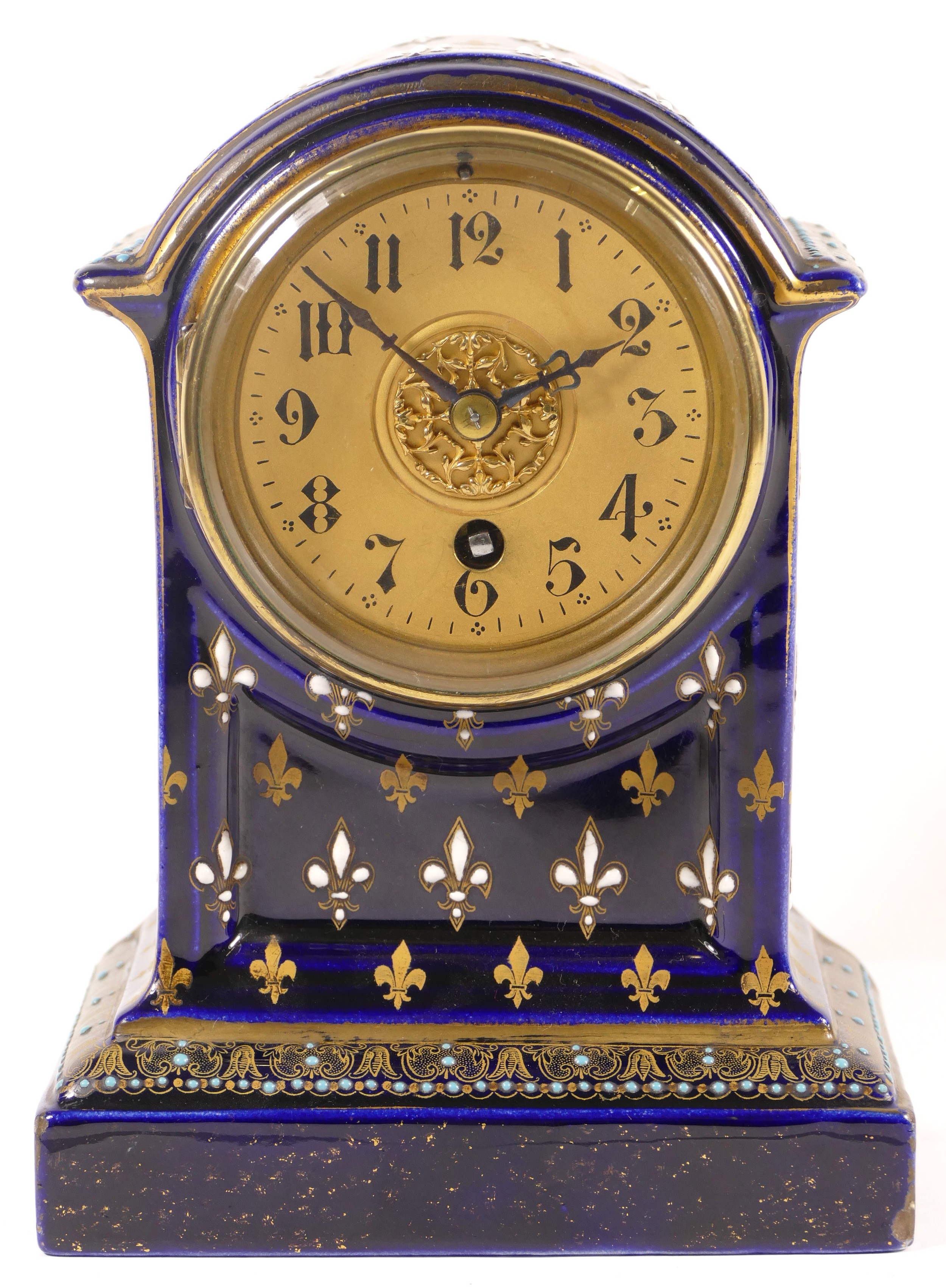An early 20th century cobalt blue cased dome topped porcelain cased mantle clock, decorated with