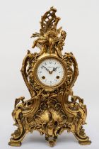 Korslant, a late 19th/early 20th century gilt brass cartouche shaped mantle clock, the white painted