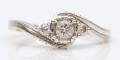 A 9ct white gold brilliant cut diamond dress ring, the middle stone flanked by two smaller diamonds,