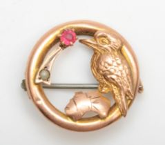 A Victorian 9ct gold circular brooch, 20 mm, set with a pink paste stone, a kookaburra and