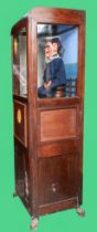 Laughing sailor, HMS Happy, by Modern Enterprises, stained oak cabinet, raised on cast