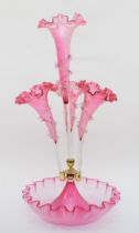 A late 19th/early 20th century cranberry glass three trumpet epergne with central trumpet, standig