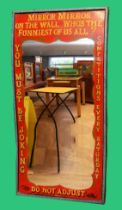 An early 20th century fairground illusion mirror, hand painted decoration in a pine case, 90 x 184