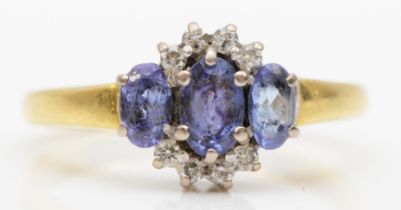 An 18ct gold three stone tanzanite and brilliant cut diamond ring, P, 4.5gm.