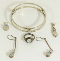 A silver and moonstone bangle, a pair of ear pendants, a pendant and a ring, 41gm