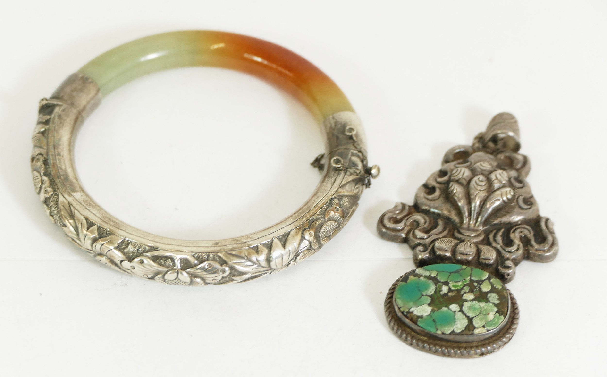 A Chinese silver and mottled jadeite hinged bangle, 56mm internal diameter and a Chinese silver