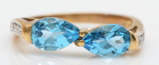 A 9ct gold two stone blue topaz ring, set with eight cut diamond shoulders, O, 2.6gm.