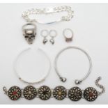 A 925 stamped silver ID bracelet, a pair of skull earrings stamped 925, an unmarked skull ring and