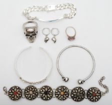 A 925 stamped silver ID bracelet, a pair of skull earrings stamped 925, an unmarked skull ring and