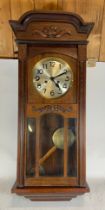 A 1930s mahogany cased hanging wall clock, the silvered dial with black Arabic numerals, 84cm long