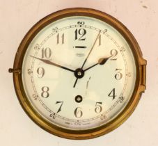 A Tempora brass bulkhead clock, circa early 20th century, made in England, having an 8 day movement,