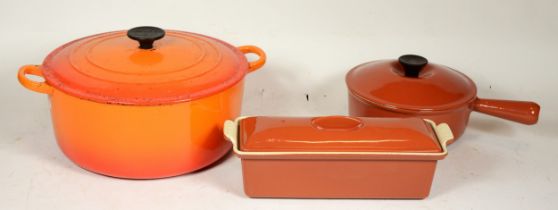 Three pieces of Le Creuset cast iron cooking pans to include a large casserole pot, saucepan and a