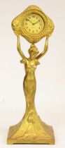 An Art Deco style figural table clock, the gilt spelter of a lady holding a clock a loft, the 8