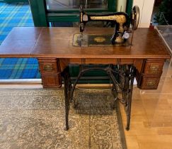 An early 20th century mahogany cased and cast iron Singer treadle sewing machine, 88cm wide